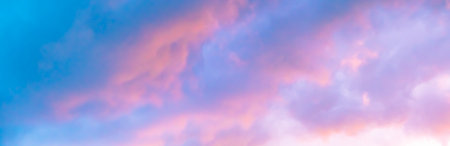 Blue morning sky is in pink clouds. Sunrise clouds are in vanilla colours. Beauty in nature. Twilight time, golden hour. Details of evening sunset. Natural abstraction. Peace concept. Panoramic view.の写真素材