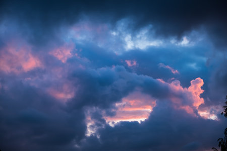 Dark blue sky clouds with pink holes. Storm weather. Beauty in nature. Twilight, golden hour. Thunderstorm. Details of evening sunset. Natural abstraction. Peace concept. Panoramic landscape view.の写真素材
