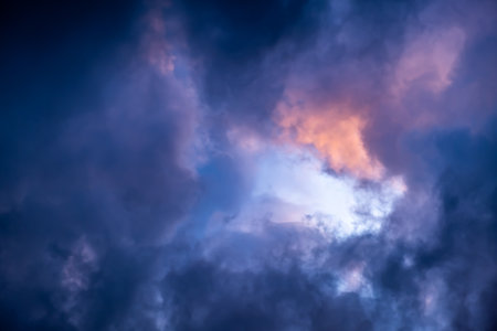 Blue hole in the dark cloudy sky. Storm Clouds. Evening sunset. Rainy and stormy weather. Art wallpaper. Natural landscape. Beauty in nature. After thunderstorm. The hope concept. High quality photo.の写真素材