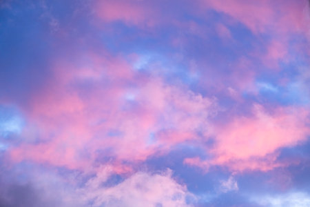 Blue morning sky is in pink clouds. Sunrise clouds are in vanilla colours. Beauty in nature. Twilight time, golden hour. Details of evening sunset. Natural abstraction. Peace concept. Panoramic view.の写真素材