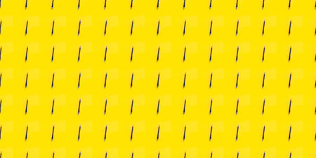 Repeating black pens on a yellow background. Seamless pattern. Concept for learning, literature, writing texts, school accessories. Bright business wallpaper. High quality photo.の写真素材