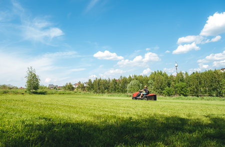 Man on lawn tractor mowing lawn on backyard. The red rider. The lawnmower tractor. High quality 4k...