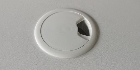 Empty hole for electric wire and cable on computer desk. Without wires. Furniture on the table. White color. Top view. High quality photo.の写真素材