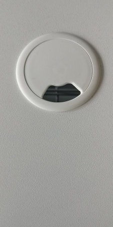 Empty hole for electric wire and cable on computer desk. Without wires. Furniture on the table. White color. Top view. High quality photo.の写真素材