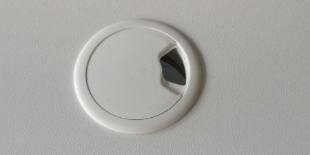 Empty hole for electric wire and cable on computer desk. Without wires. Furniture on the table. White color. Top view. High quality photo.の写真素材