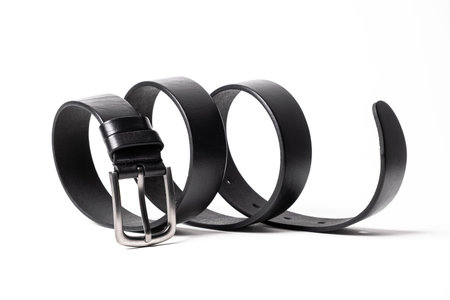 Black leather belt with matte metal buckle close-up isolated on white background. Fashionable unisex...