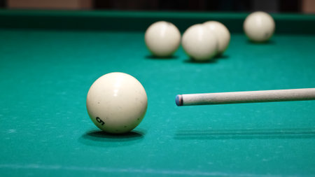 The cue aiming and hits the white cue ball on a green table. Playing russian billiard game. Accurate...