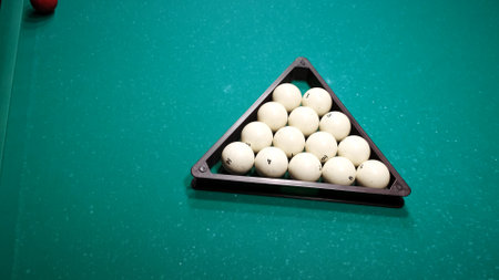 Billiard balls in a triangle on a green pool table. Preparing the pyramid for the new game. Pastime playing sport hobby.の写真素材