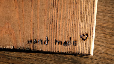 Burned out the inscription Hand made. Woodburning or pyrography. Drawing on a wooden plank with pyrograph. Wood burning creative hobby. Art class workshop. Creative activity. Highの写真素材
