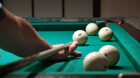 Playing Russian billiards on a green felt table. Player hits cue ball missing the pocket. Unsuccessful attempt. A failure game. Hobby pastime. Corner pocket side viewの写真素材