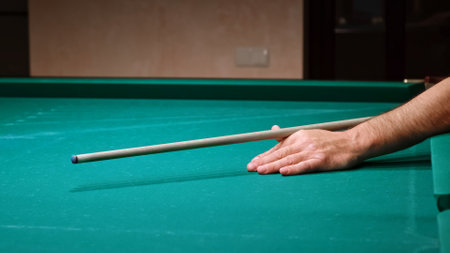 The position of players hand with the cue on thebilliard table. Playing russian billiard game. Accurate shot. Close-up of impact. Slow motion.Education and practicing. Correctの写真素材