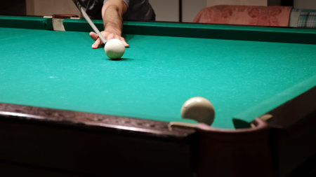 Russian billiards on a green table. American billiard. The player hits the white ball with a cue and...