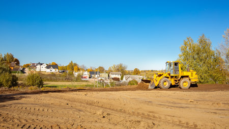 Yellow bulldozer at a construction site. Big wheel excavator leveling and clearing the land plot...