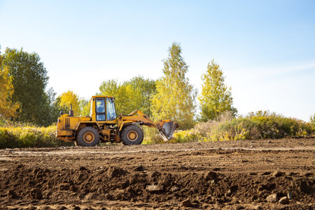 Yellow bulldozer at a construction site. Big wheel excavator leveling and clearing the land plot...
