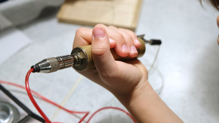 Electrod in hand. A patient holds a brass handpiece of bioenergetic testing device. Diagnoses with...