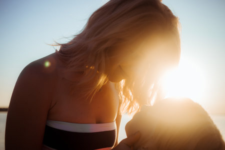 Sunny day, mom and daughter hug and chat together. Summer time vacation or holiday weekend on the beach. Psychology of communication of a single mother with a child. Close-up.の写真素材