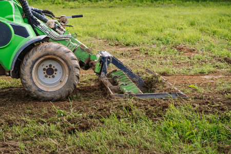Land work by the territory improvement. Small tractor with a ground leveler for moving soil, turf. A...
