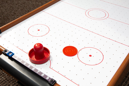 Subject shot of air hockey game table close-up. The portable table hockey includes plastic hockey...