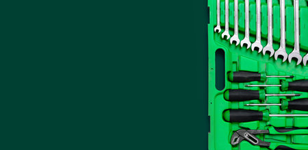Green set of construction tools: wrenches, adjustable pliers, screwdrivers and so on on a red background. Banner with place for text for a hardware store. Metal hardware forの写真素材