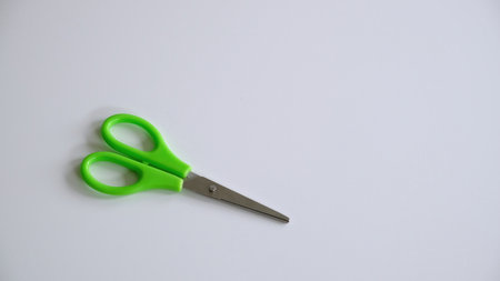 Scissors with green handles isolated on white background. Childrens stationery. High quality photo.の写真素材