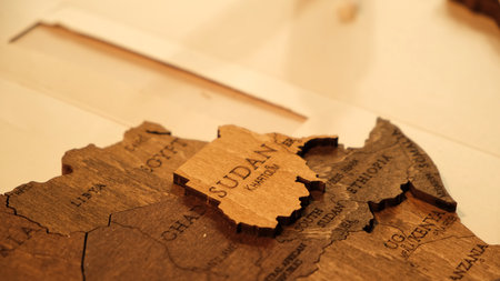 Wooden World map of earth showing African continent on a workshop tabletop. Making of interior decor for travel, geography. Hobby concept. Gluing of plywood details gluing togetherの写真素材