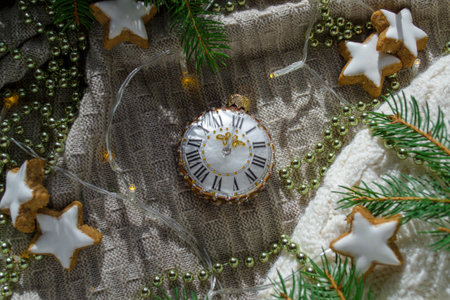 Christmas tree toy in the shape of a clock among the branches of a Christmas tree and Christmas...