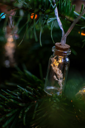 Luminous glass garland filled with dry branches on a spruce branch