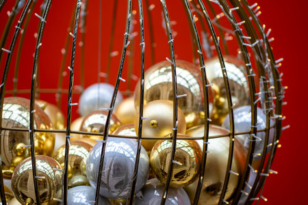 Many colorful Christmas balls in a metal basket decorated with garland.の写真素材
