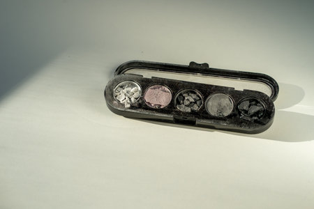 Broken eyeshadow palettes on a white table. Decorative cosmetics.