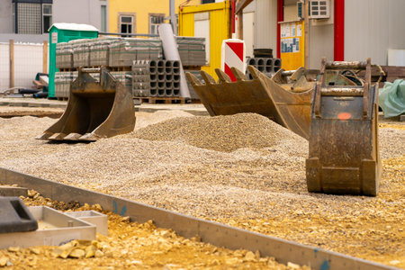 Excavator bucket picks up crushed stone for road repair.の写真素材