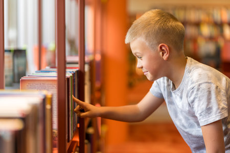Smart intelligent preschool kid choosing books in school library.の写真素材