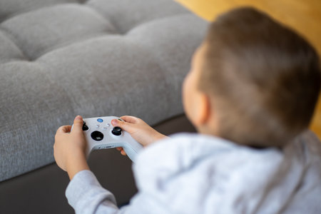 Top view of a boy in a gray hoodie playing on a game console.の写真素材