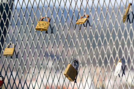 View of many old rusty padlocks on the iron fence of the bridgeの写真素材