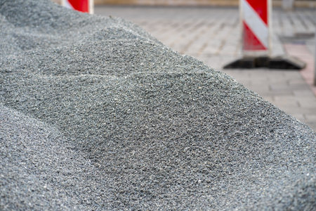 Piles of rubble at a construction site with safety signs in the backgroundの写真素材
