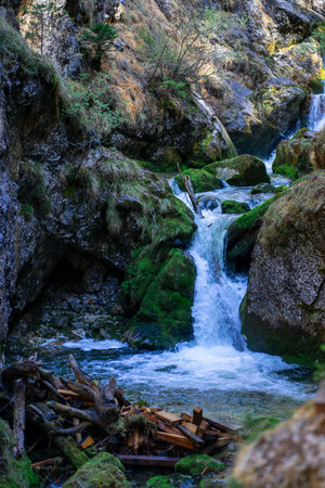 The cascades of a mountain river between the Alpine mountains on a sunny dayの写真素材