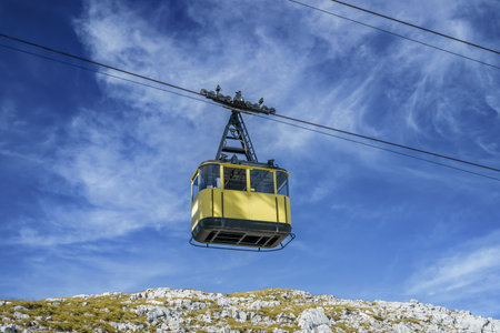 Yellow suspended gondola on a cable car in the Austrian Alps. Cable car in Dachstein against the skyの写真素材