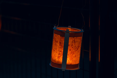 A paper lantern made by a child glows at night during the traditional festival. Paper lantern create a serene festive atmosphereの写真素材