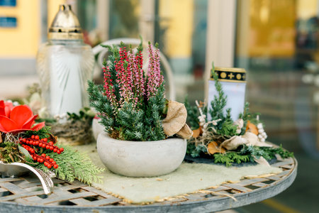 A peaceful autumn arrangement featuring heather, evergreens and candles placed on a rustic table.の写真素材