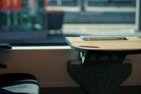 Minimalist interior of a modern train with wooden table near window. Comfortable public transport...
