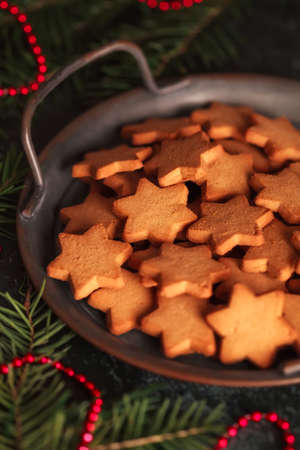 Cookies in the form of stars for Christmas and new year's table on a dark background in vintageの写真素材
