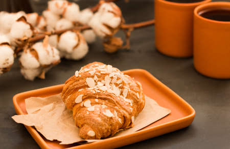 Croissant with almonds and cream filling. Traditional French Breakfast. Breakfast with coffee and...