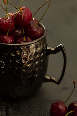 Bright juicy red cherries in a glass. Macro Red cherries with water dropsの写真素材