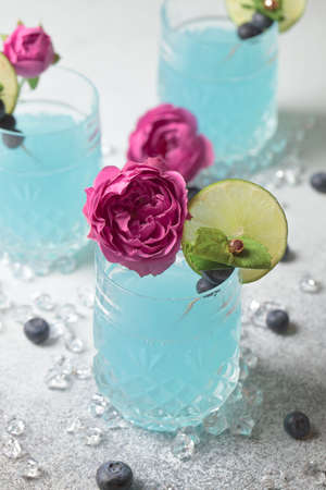 Blue soda. Ice blue cocktail glass. Blue Hawaiian cocktail on a white plate with lime. Blue curacao...