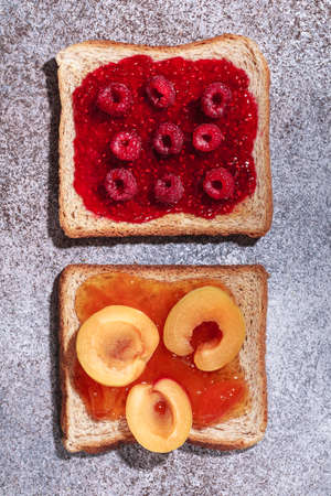 Toast with jam. Raspberry and apricot jam with berries. Fruit jam for Breakfast. Fresh and healthy breakfast with toastの写真素材