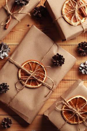 Gifts for Christmas and New Year. packed craft gifts with cinnamon and orange for decoration.の写真素材