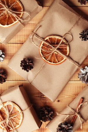 Gifts for Christmas and New Year. packed craft gifts with cinnamon and orange for decoration.の写真素材