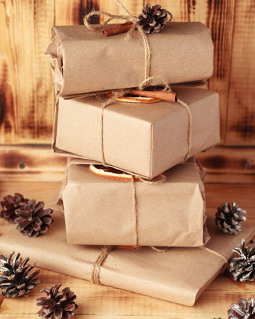 Gifts for Christmas and New Year. packed craft gifts with cinnamon and orange for decoration.
