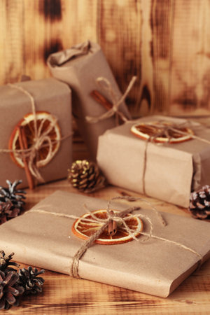 Gifts for Christmas and New Year. packed craft gifts with cinnamon and orange for decoration.の写真素材