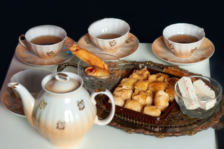 Teapot, teacups and sweetsの写真素材