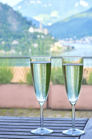 Two glasses of champagne and lake on backgroundの写真素材